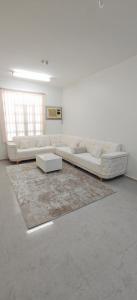 una sala de estar blanca con sofás blancos y una alfombra en Masa Nizwa ماسة نزوى, en Nizwa