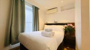 a bedroom with a bed with a towel on it at Osborne Aparthotel in Eastbourne