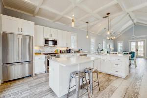 une grande cuisine avec des armoires blanches et des appareils en acier inoxydable dans l'établissement Paradise Found at Palmilla Beach, à Port Aransas