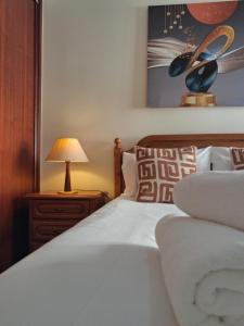 a bedroom with a white bed with a lamp on a night stand at Ribeira Brava Studios - L in Ribeira Brava