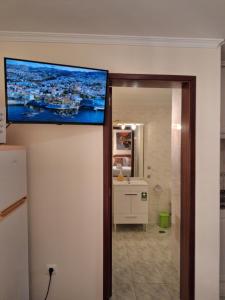 a flat screen tv on the wall of a bathroom at Ribeira Brava Studios - L in Ribeira Brava