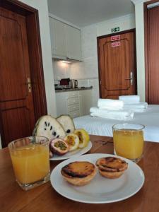 a table with plates of food and two glasses of orange juice at Ribeira Brava Studios - L in Ribeira Brava