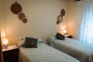 a bedroom with two beds and two lamps on the wall at Ca Margarita in Benegida +30 photos