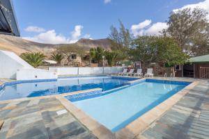 ein Schwimmbad in einem Resort mit Bergen im Hintergrund in der Unterkunft Vivienda Vacacional Sara in Tetir