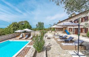 una piscina all'aperto con sedie e ombrelloni di Villa Kluni by Rent Istria a Momjan