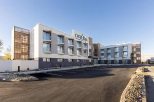 马尔萨克Hôtel OstOria Périgueux, BW Signature Collection的建筑物前的空停车场