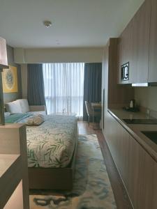 a hotel room with a bed and a kitchen at Cleo Suites at Novotel Hotel Residences near Makati in Manila