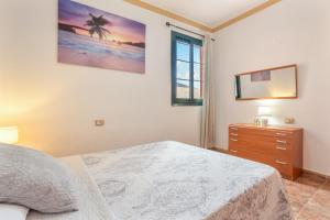 ein Schlafzimmer mit einem Bett, einer Kommode und einem Spiegel in der Unterkunft Vivienda Vacacional Sara in Tetir + 29 Fotos