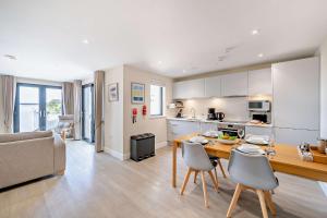 a kitchen and living room with a table and chairs at 12 Middlecombe - Luxury Apartment at Byron Woolacombe, only 4 minute walk to Woolacombe Beach! in Woolacombe