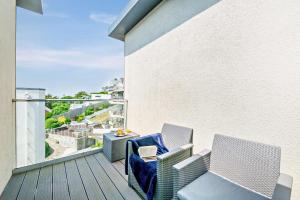a balcony with two chairs and a table at 12 Middlecombe - Luxury Apartment at Byron Woolacombe, only 4 minute walk to Woolacombe Beach! in Woolacombe