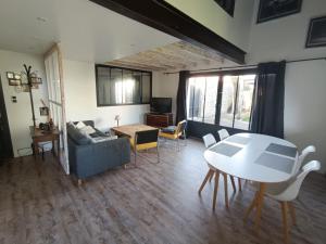 a living room with a table and a couch at L'Atelier du Clos avec Jacuzzi in Puilboreau