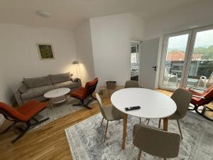 a living room with a table and chairs and a couch at Mountain View Lux Apartment in Sarajevo
