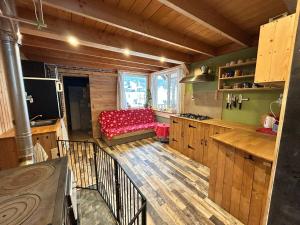 - une cuisine avec un canapé rouge dans une chambre dans l'établissement Tiny House at Sedliacky Dvor - Brezno, à Brezno