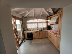 una cocina con armarios de madera y una gran ventana en H41 Attico in centro, en Budoni
