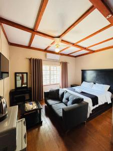 a bedroom with a large bed and a couch at DeRockview Lodge in Johannesburg