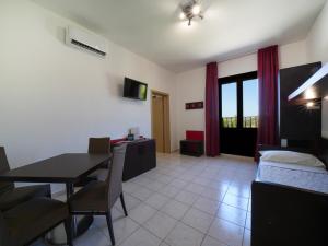 un soggiorno con un tavolo e una sala da pranzo di Resort Villa Hermosa a Porto Cesareo