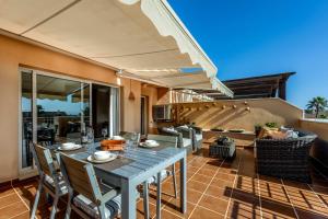 a patio with a table and chairs and an umbrella at Jardines de Santa Maria Golf in Marbella