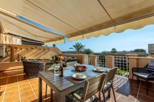 a patio with a table and chairs and an umbrella at Jardines de Santa Maria Golf in Marbella