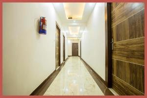 un largo pasillo con un extintor en la pared en Near Mahakal Temple G- Residency Near Railway Station - Air Conditioned hotel at Prime Location - Lift and Parking - BEST HOTEL IN UJJAIN, en Ujjain