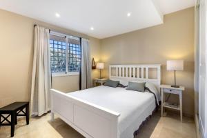 a bedroom with a white bed and a window at Jardines de Santa Maria Golf in Marbella +63 photos