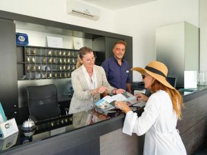 un gruppo di persone che si trovano in un registratore di cassa di Resort Villa Hermosa a Porto Cesareo Altre 161 foto