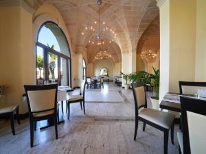 una sala da pranzo con tavoli e sedie in un edificio di Resort Villa Hermosa a Porto Cesareo