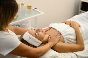 a woman is giving a massage to a patient at Colosseum Hotel in Mórahalom