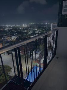 a balcony with a view of a city at night at Sitari Condo Bacolod in Bacolod