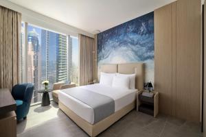 a hotel room with a bed and a large window at Ciel Dubai Marina, Vignette Collection by IHG in Dubai