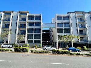ein großes Gebäude, vor dem Autos parken in der Unterkunft Urban L010 in Durban