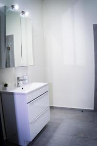 a white bathroom with a sink and a mirror at Urban76 Apartments in Târgu-Mureş +12 photos