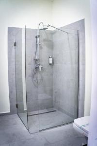 a shower with a glass door in a bathroom at Urban76 Apartments in Târgu-Mureş