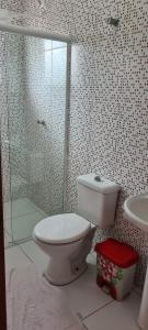 a bathroom with a toilet and a shower and a sink at Residencial Jmulguero in Guaratuba
