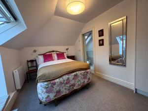 卡舍尔Cashel Regency Townhouse的一间卧室，里面有一张大床，床上放着粉色的枕头。