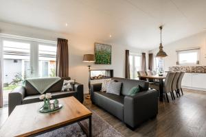 Schaelsbergerbosch Eco - Garden House Sauna copy في بيرغ إين تيربيلييت: غرفة معيشة مع أريكة وطاولة