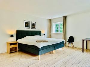 a bedroom with a large bed and a desk at Large Holiday Home With Pool On South Lolland Coast in Dannemare +31 photos