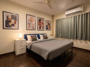 a bedroom with a large bed and some paintings at hotel elevate suites in Nagpur