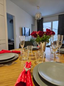 罗瓦涅米Snow Queen's residence的餐桌上摆放着红玫瑰和玻璃杯