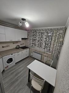 a kitchen with a table and chairs in a room at Buiucani in Chişinău