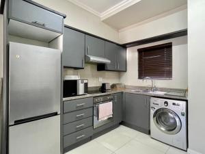 eine Küche mit einem Kühlschrank aus Edelstahl und einem Geschirrspüler in der Unterkunft Urban L010 in Durban