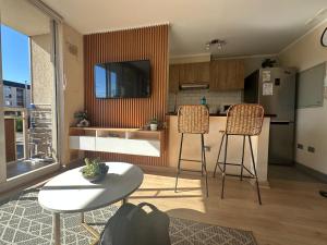 een keuken met een aanrecht en twee krukken en een tafel bij Acogedor departamento completamente equipado in Villarrica