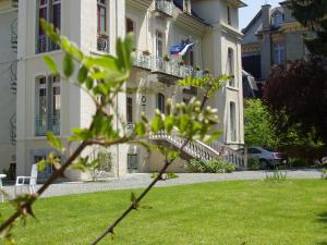 een groot wit gebouw met een vlag erop bij Castel de la Pique in Luchon