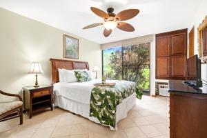 MarconiNEW Kuilima Estates West 1135 FREE CAR KBM的一间卧室，里面有一张床和一个吊扇 更多21张照片