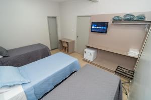 Bandeirantes Hotel في كويابا: غرفة صغيرة بسريرين وتلفزيون +50 صورة