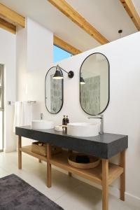 un baño con dos lavabos y dos espejos en Goats Window Luxury Safari Lodge, en Bonnievale