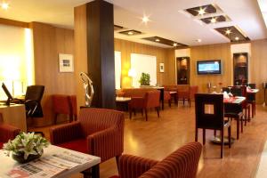 a restaurant with tables and chairs and a waiting room at Hampshire Plaza in Hyderabad