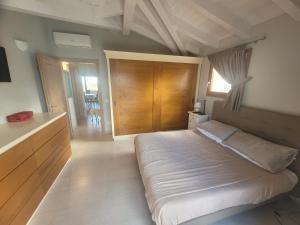 Un dormitorio con una cama grande con cabecero de madera. en H41 Attico in centro, en Budoni