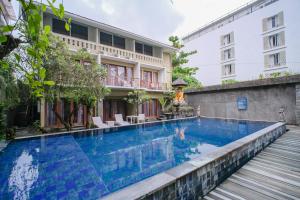 a swimming pool in front of a building at Kamini Legian Hotel in Legian