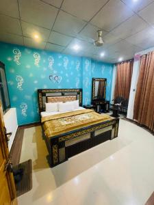 una camera da letto con un letto con una parete blu di Green land hotel a Mingora