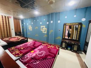a room with two beds and a mirror and a woman taking a picture at Green land hotel in Mingāora